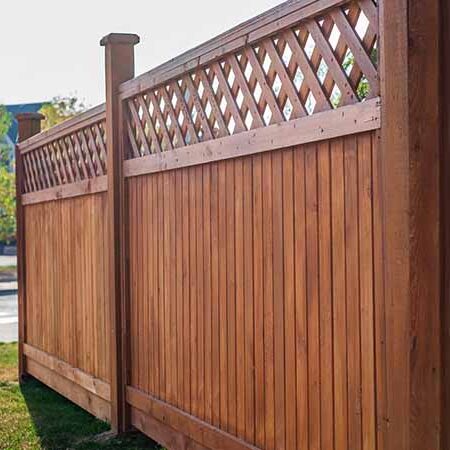 Stained wooden fence with lattice pattern